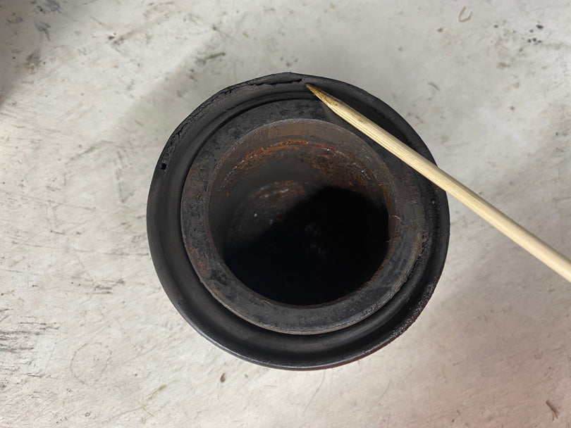 Brake caliper piston with dust boot shown torn.