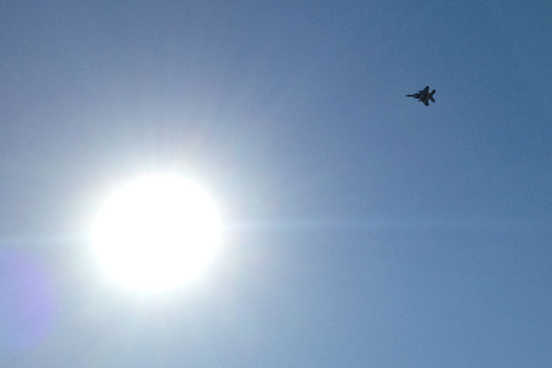 Fighter jet flying overhead.