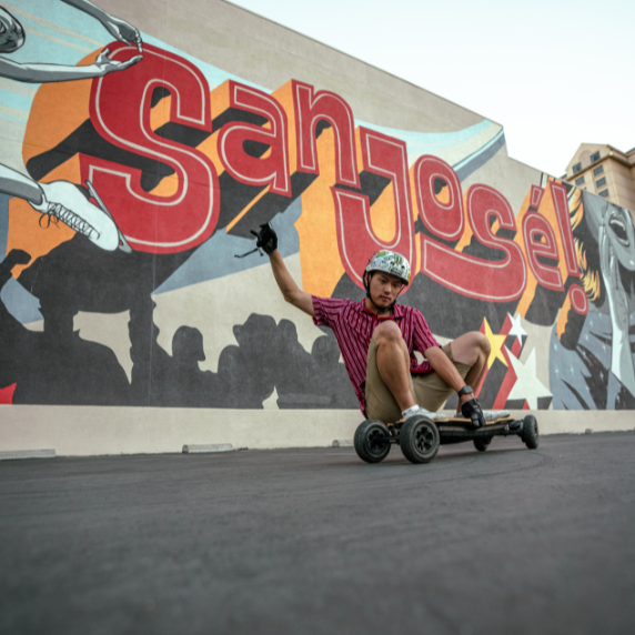 guy riding an electric skateboard in a carpark