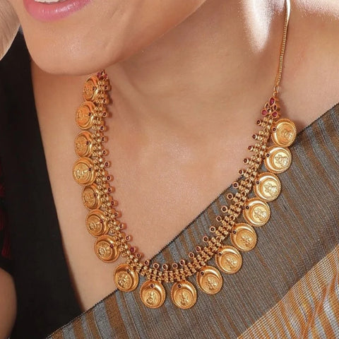 A close up image of a woman wearing an antique necklace