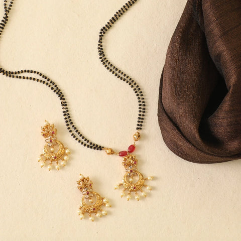 An image of an Indian black beads mangalsutra on a beige background