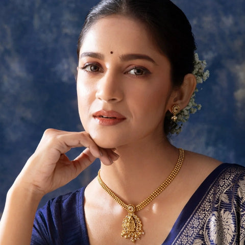 An image of a woman wearing an Indian necklace sets with saree.