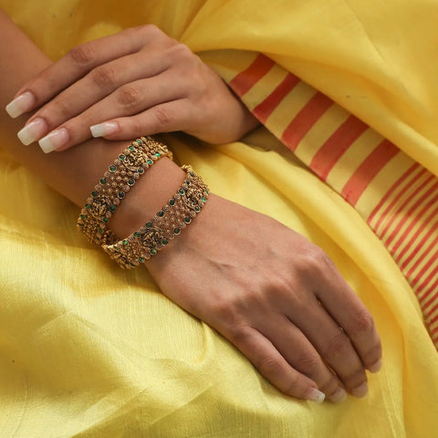 An image of a woman wearing antique temple bangles.