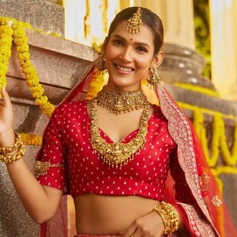 An image of an Indian bride, wearing temple styled antique jewellery including necklaces, earrings and bangles.