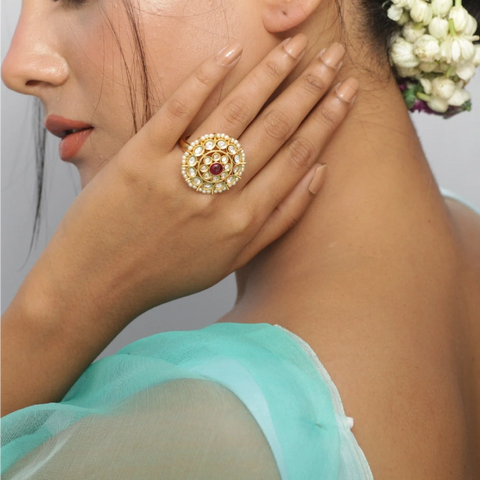 An image of a woman wearing a finger ring with kundan stones.