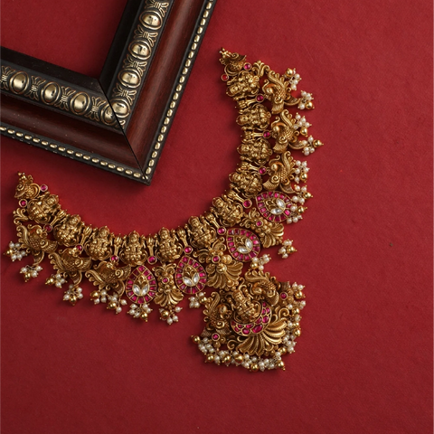 An image of an antique temple necklace on the red background