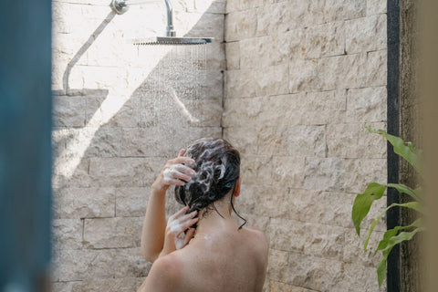Une femme en train d'appliquer du shampoing anti-pelliculaires pharmacie