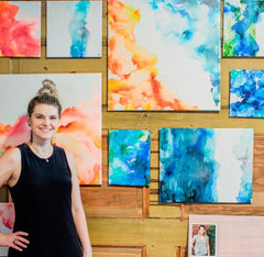 Alcohol Ink abstract artist posing infront of her paintings 