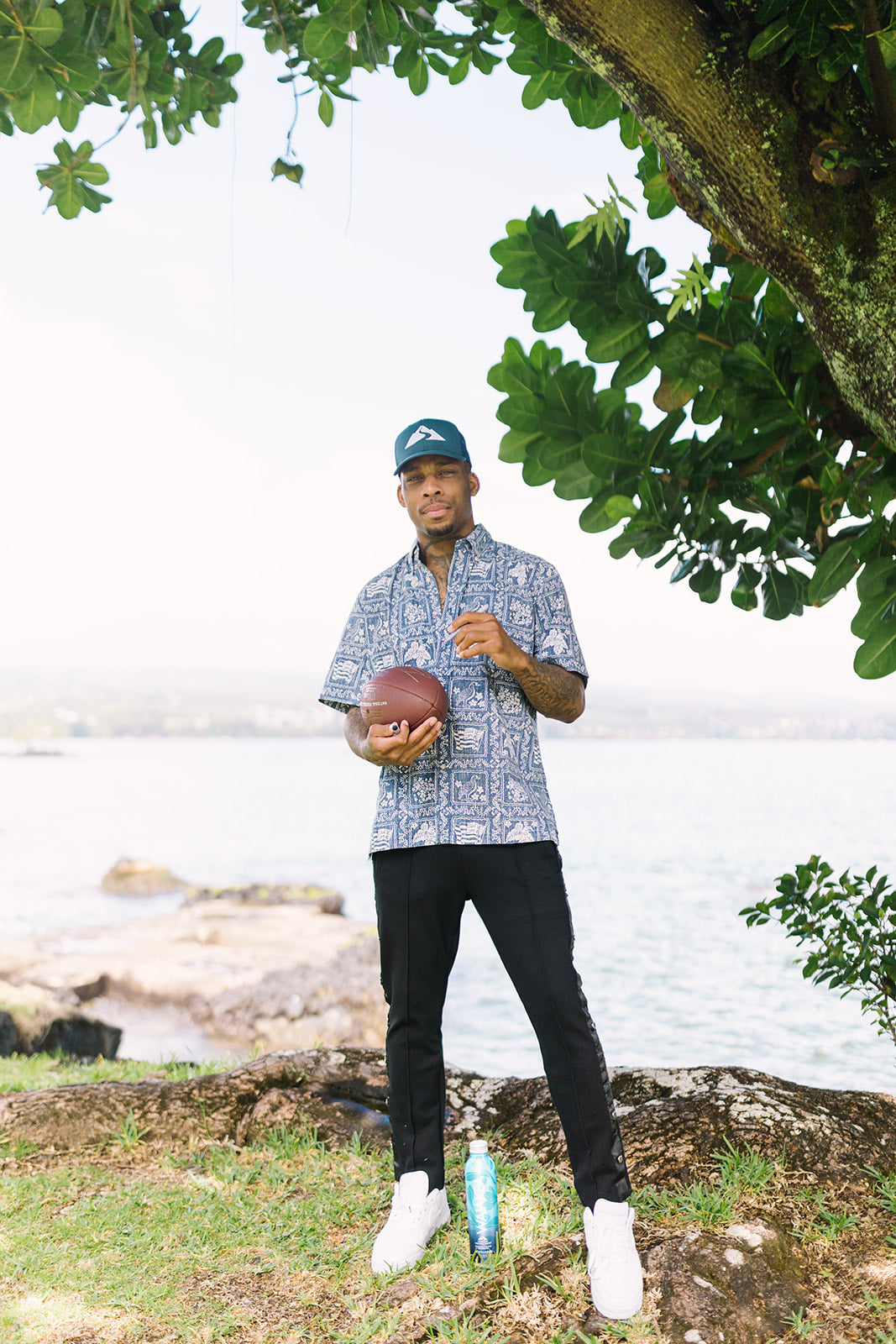 Professional football player, Troy Hill in Waiākea hat signing football