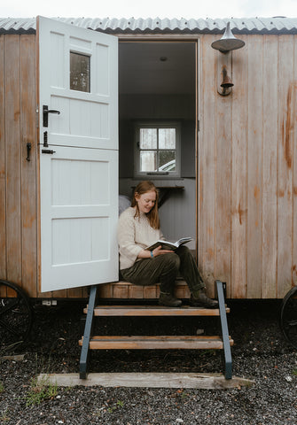 Helen sits on the steps of her caravan, where she wrote a lot of the book