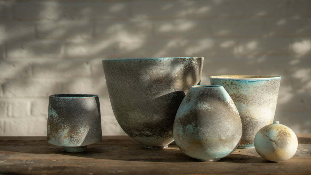 group of handcrafted soda fired vessels by potter Jack Doherty under soft interspersed sunlight