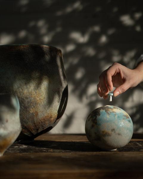 two large soda fired vessels and a small vessel by Jack Doherty with a hand inserting a tiny lid