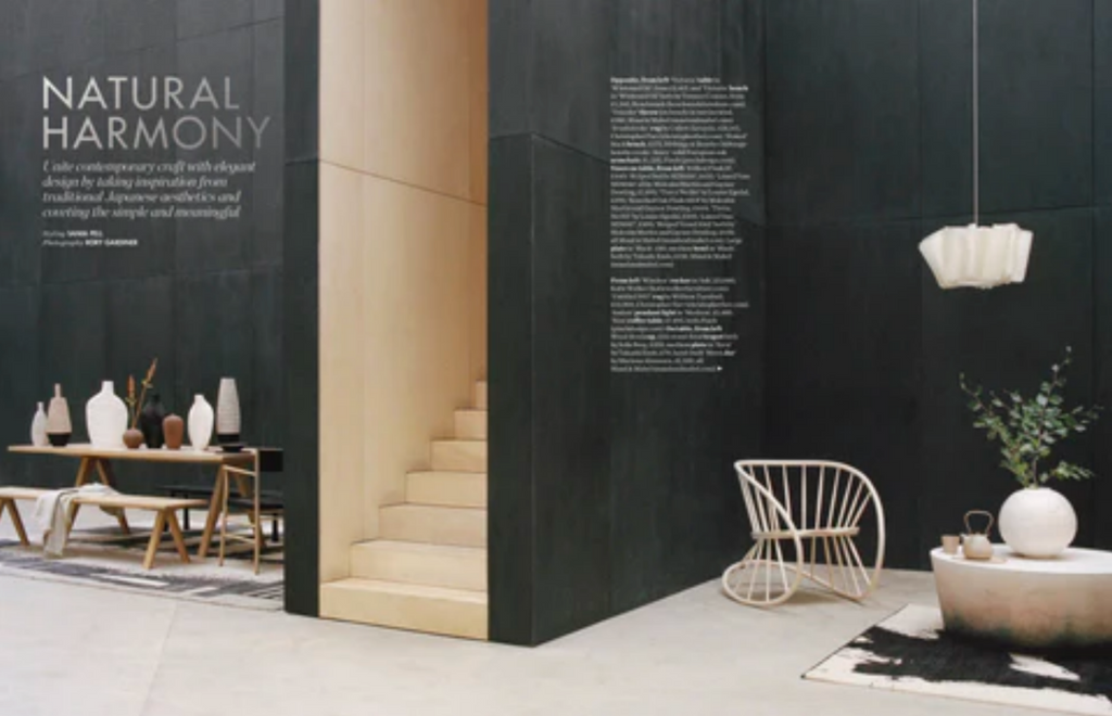 Magazine spread from Elle Decoration showing interior space with black walls, styled with pottery in neutral tones