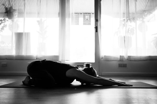 Woman stretching forward on a yoga mat