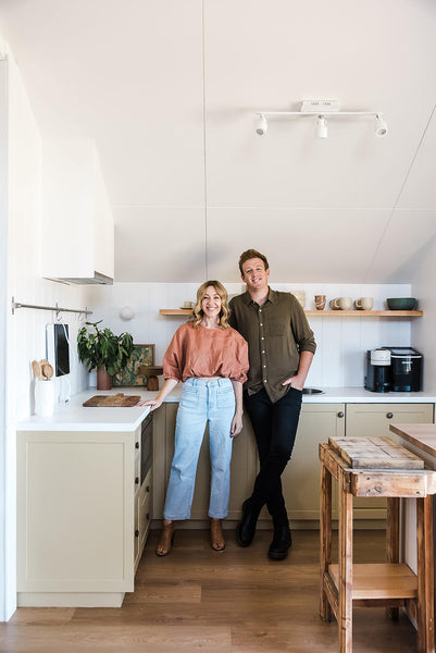 A couple stand together in their kitchen