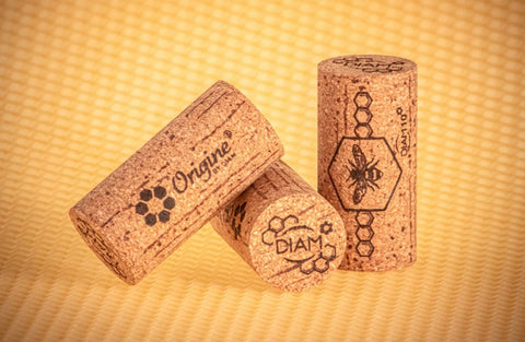 Three Diam Origine corks against backdrop of beeswax