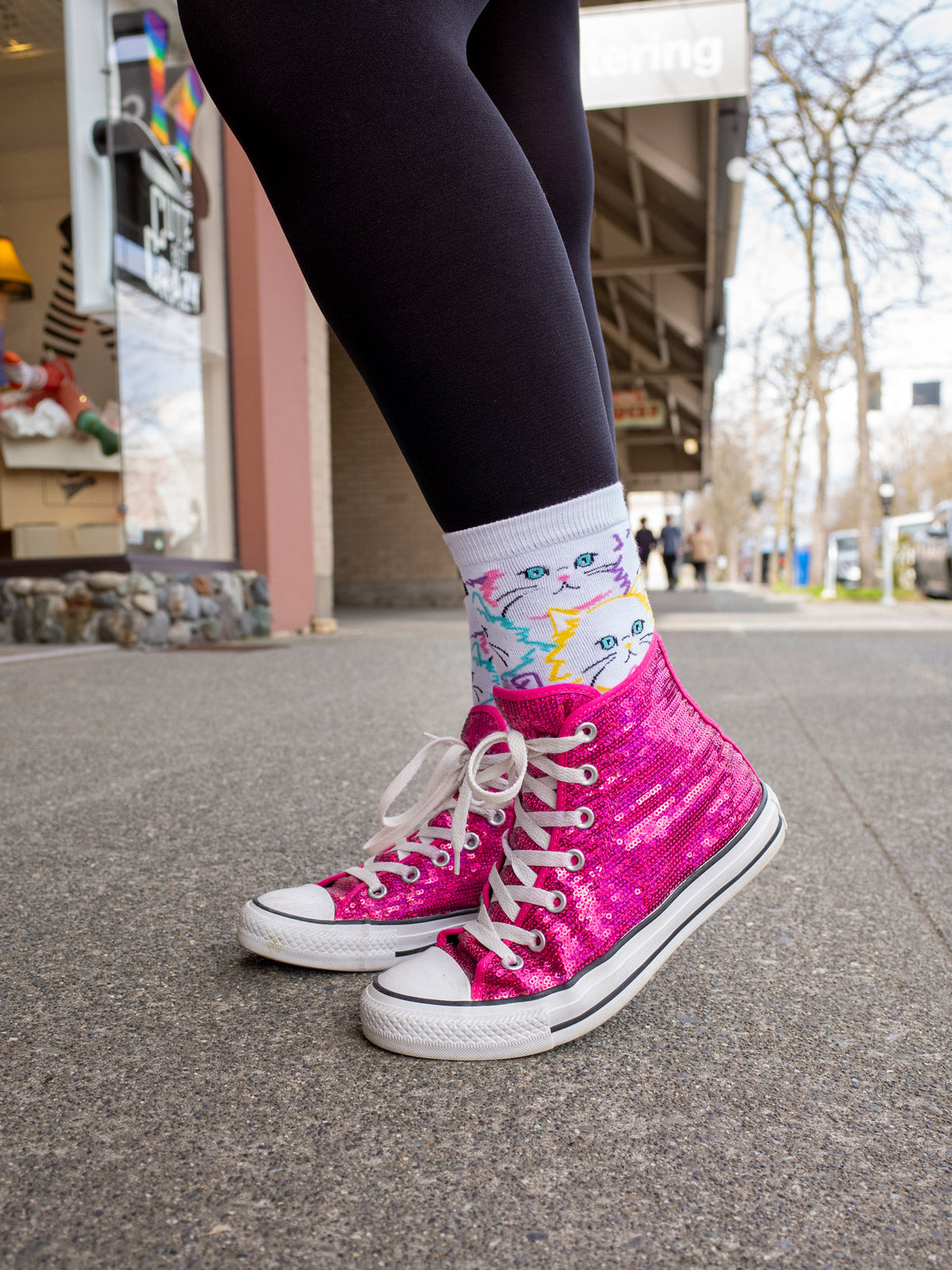 Cute cat socks are worn with magenta glitter Converse and black leggings