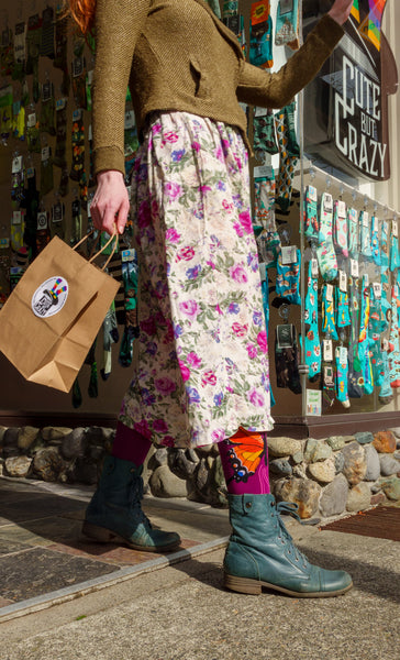 A women holds a paper shopping bag as she leaves the entrance of Cute But Crazy Socks