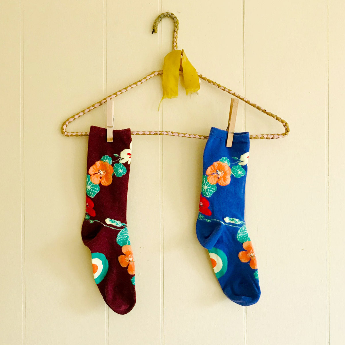 Cute floral socks with nasturtiums hang on a decorative hanger