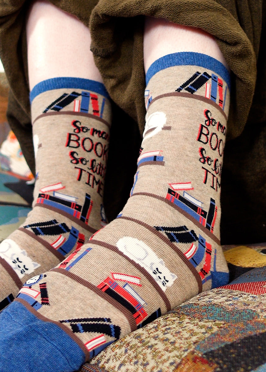 Book socks featuring shelves, a cat and the words "So Many Books, So Little Time"