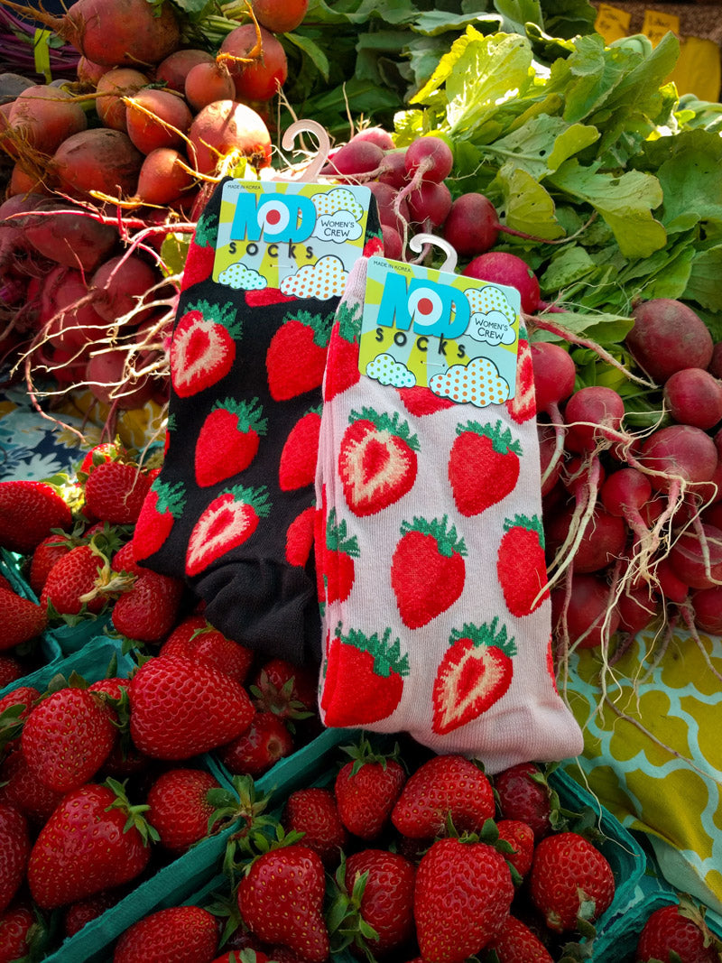 Socks with strawberries shown at a farmer's market stand with strawberries and radishes