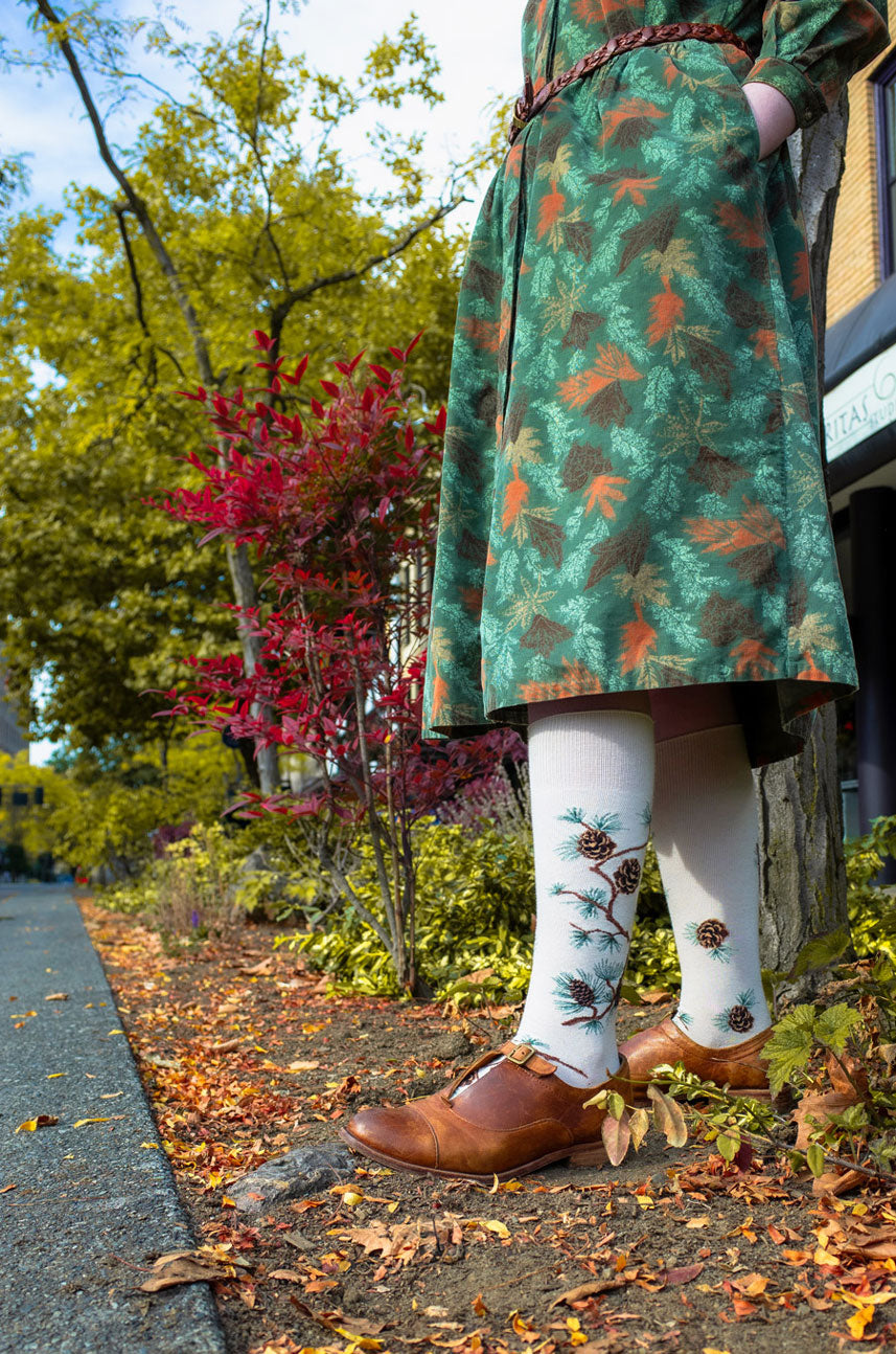 Pinecone socks worn with a corduroy dress with fall leaves pattern