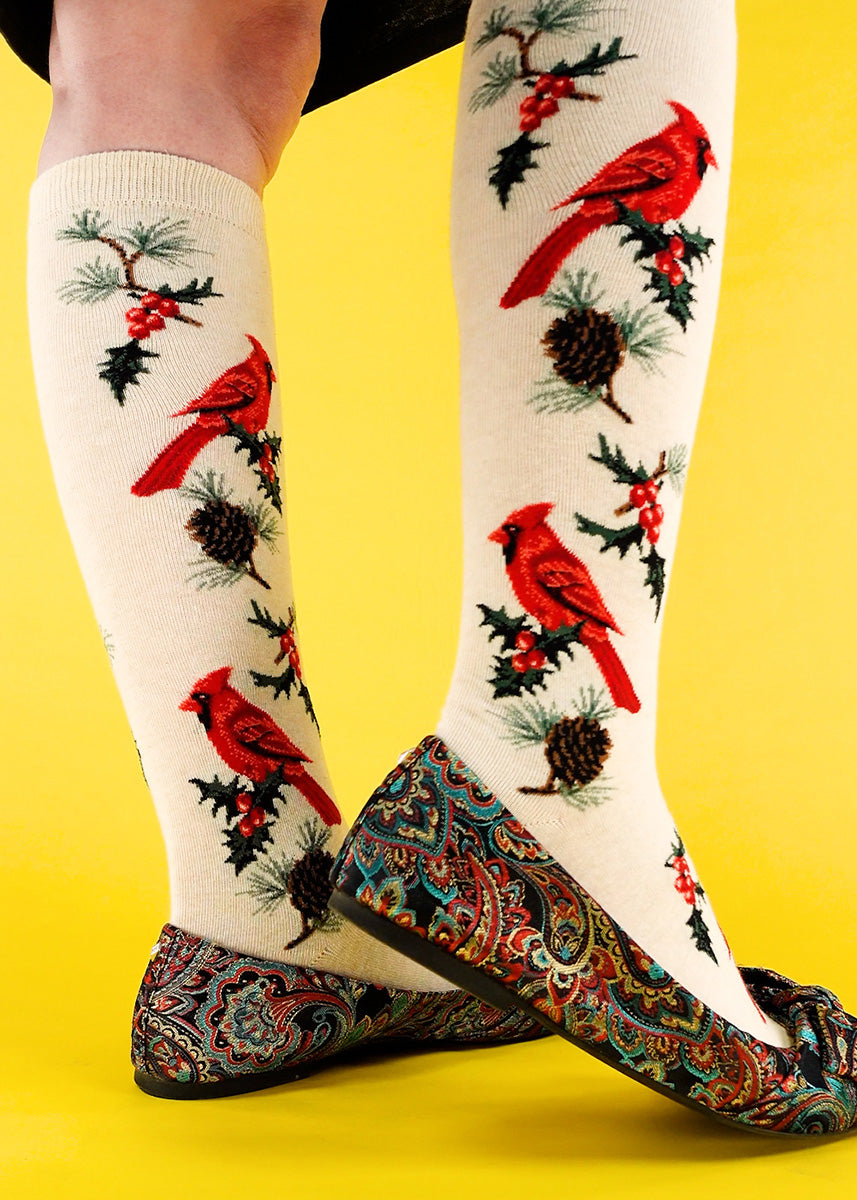 Festive cardinal bird knee socks are worn with colorful ballet flats.