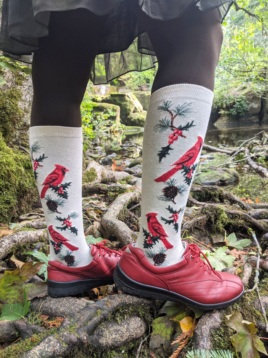 Cardinal knee socks are worn over tights with red shoes in an outdoor scene