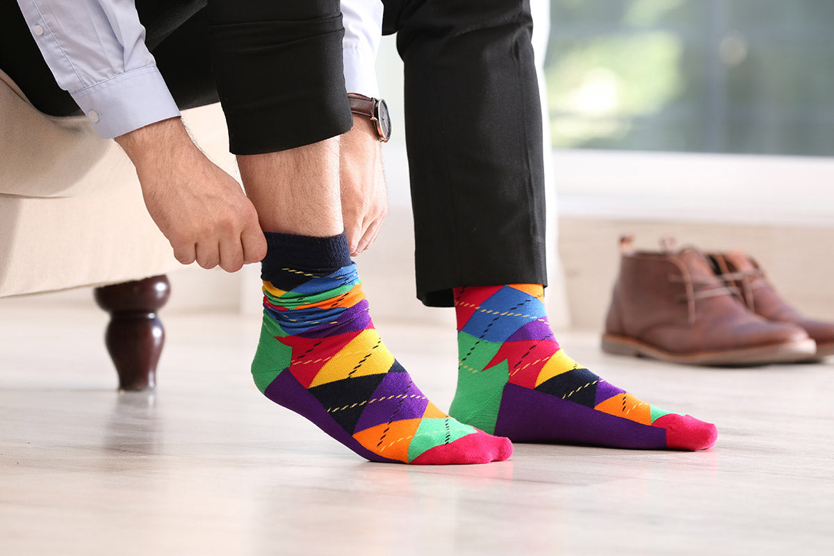 A person puts a colorful sock on their right foot