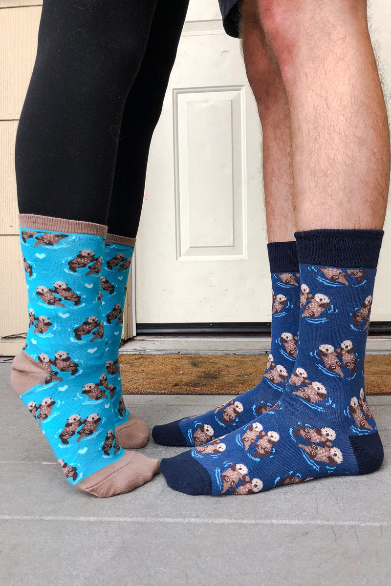 A couple faces each other wearing matching otter socks