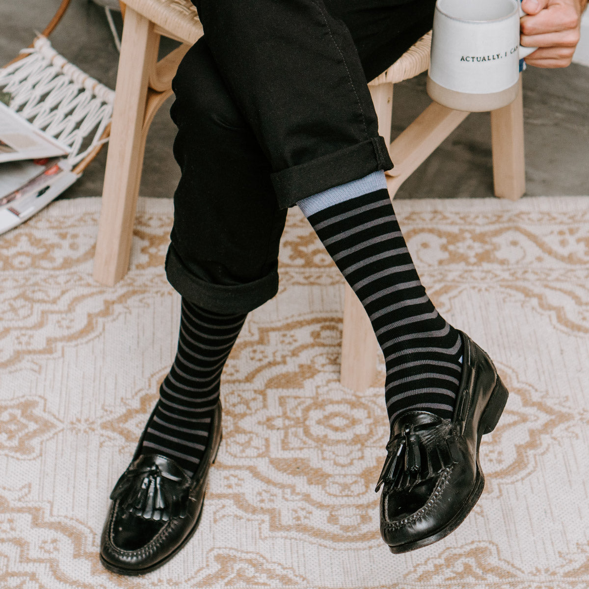A man wears tassel dress shoes with striped bamboo socks in gray and black