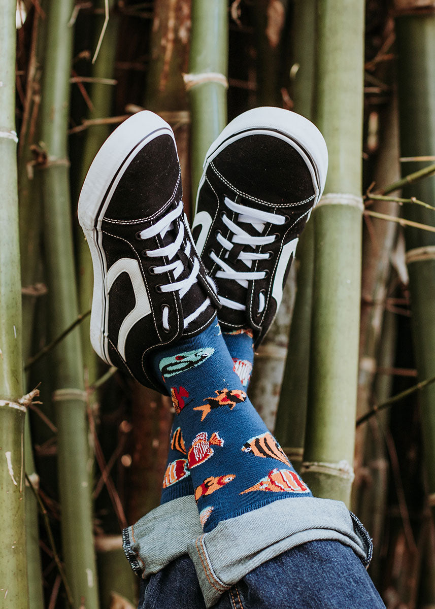 Fish socks made from bamboo fiber posed in front of a grove of bamboo stalks.