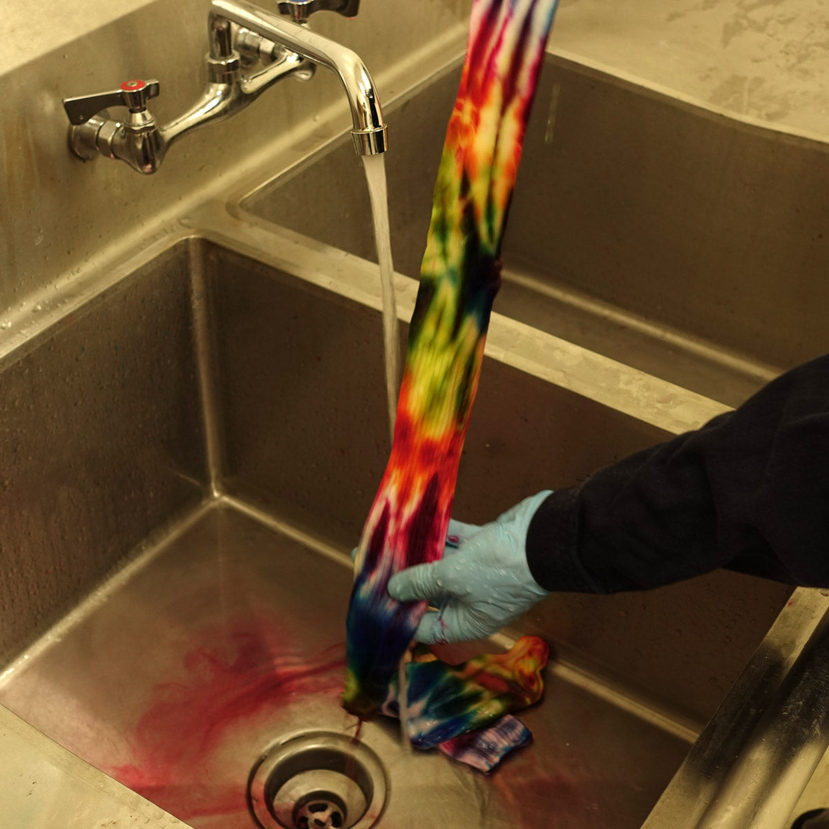 Dye washes down the drain as we rinse tie-dyed socks
