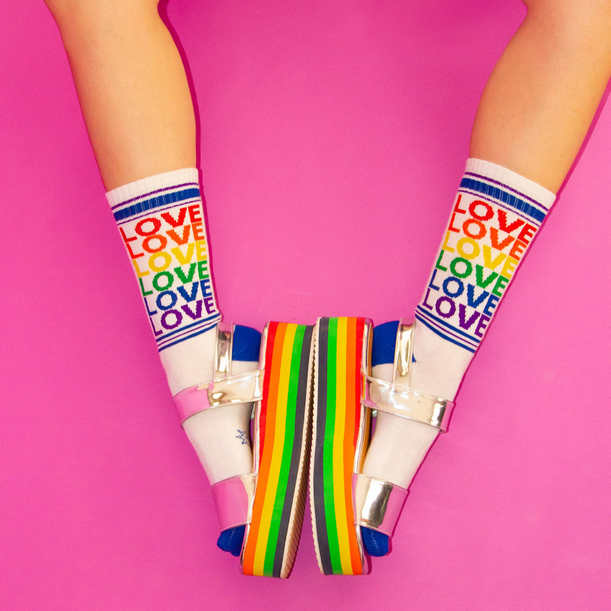 Metallic silver sandals pair with rainbow socks that say "LOVE"