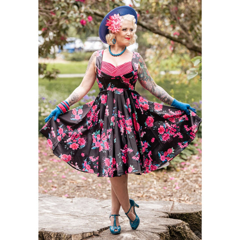 Modern blonde woman wearing a pink and black floral jive dress