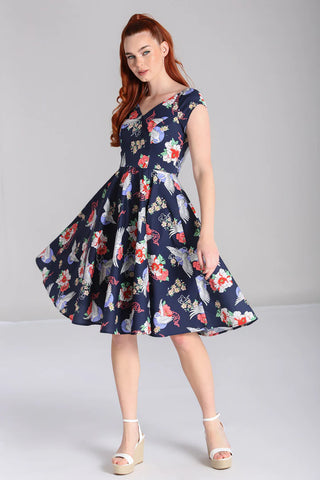 Rockabilly woman standing wearing a blue 50s fit and flare dress