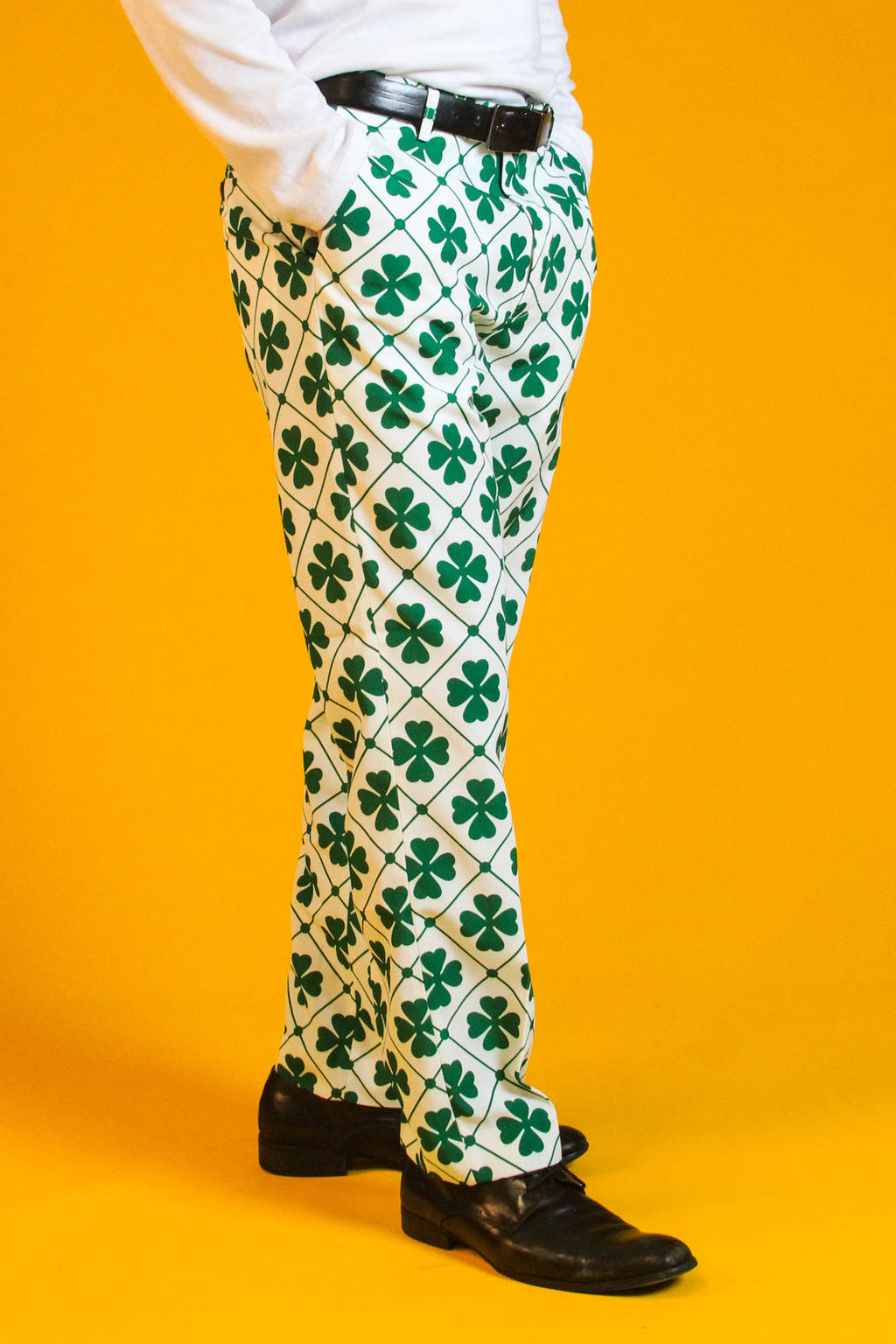 A person wearing a four-leaf clover suit with a clover pattern, belt, and shoe.