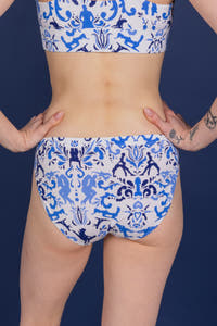 A woman wearing The Risqué Rorschach Bikini Underwear, with tattoos and a close-up of a fingernail.