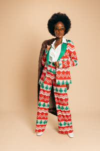 A woman in a festive knit blazer, exuding holiday style and sophistication.