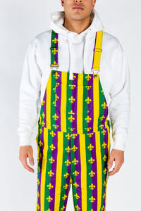 A person in Mardi Gras overalls ready for a festive day, with a front pocket for beignets.