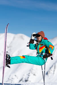 Turquoise retro ski suit on the mountain