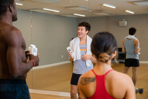 Man in fitness studio holding Boxed Water