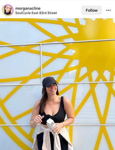 Girl standing in front of SoulCycle New York City with Boxed Water