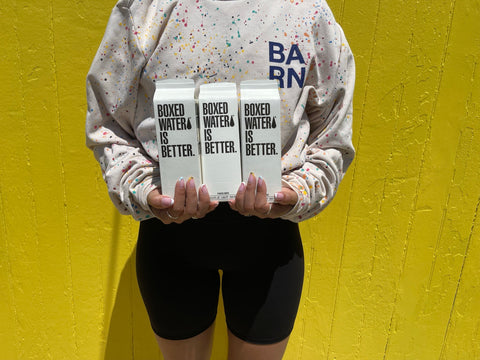 Girl at the SoulCycle BARN in the Hamptons holding Boxed Water