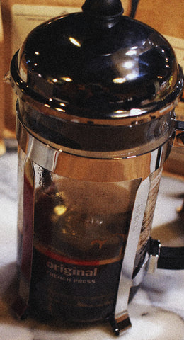 french press filled with hot coffee