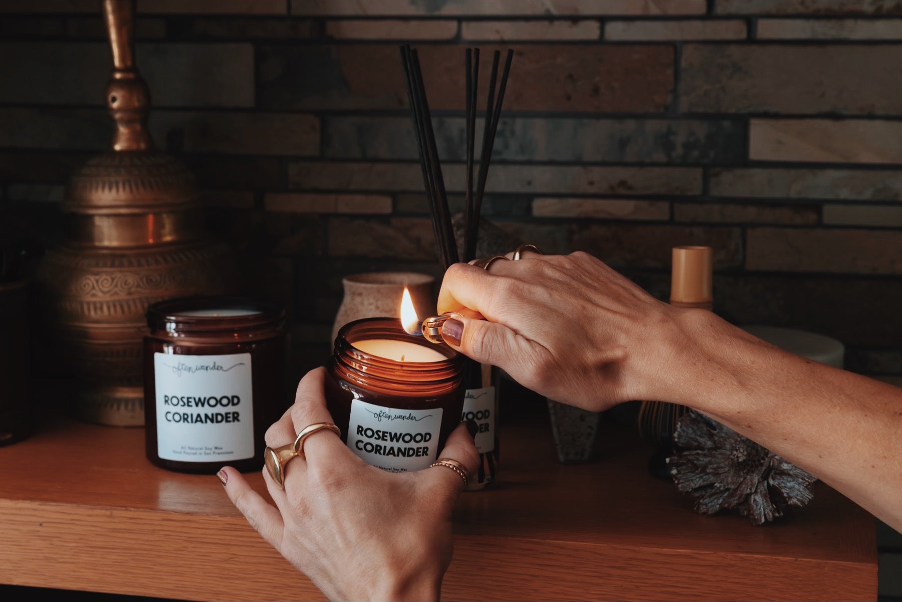 image of a hand lighting a candle on the shelf.