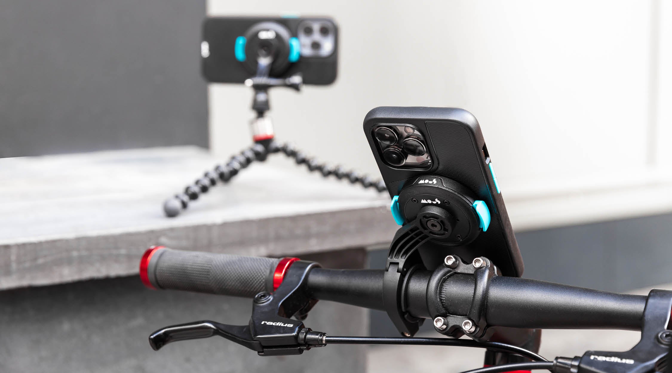 Mous IntraLock hard locking phone case on a secure phone bike mount with a phone tripod in the background