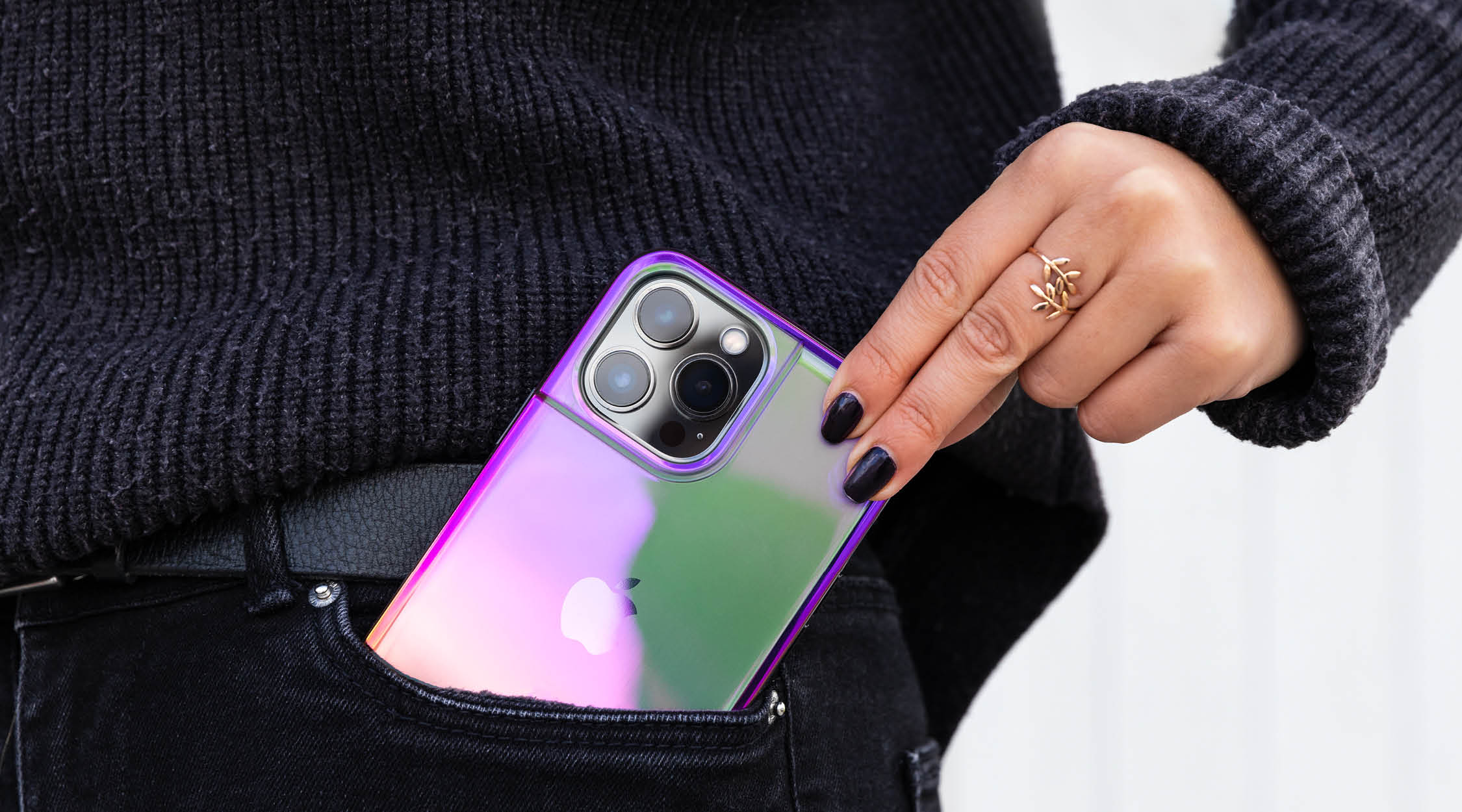 Woman wearing black taking a pink iridescent phone case for iPhone 13 Pro Max out of her pocket