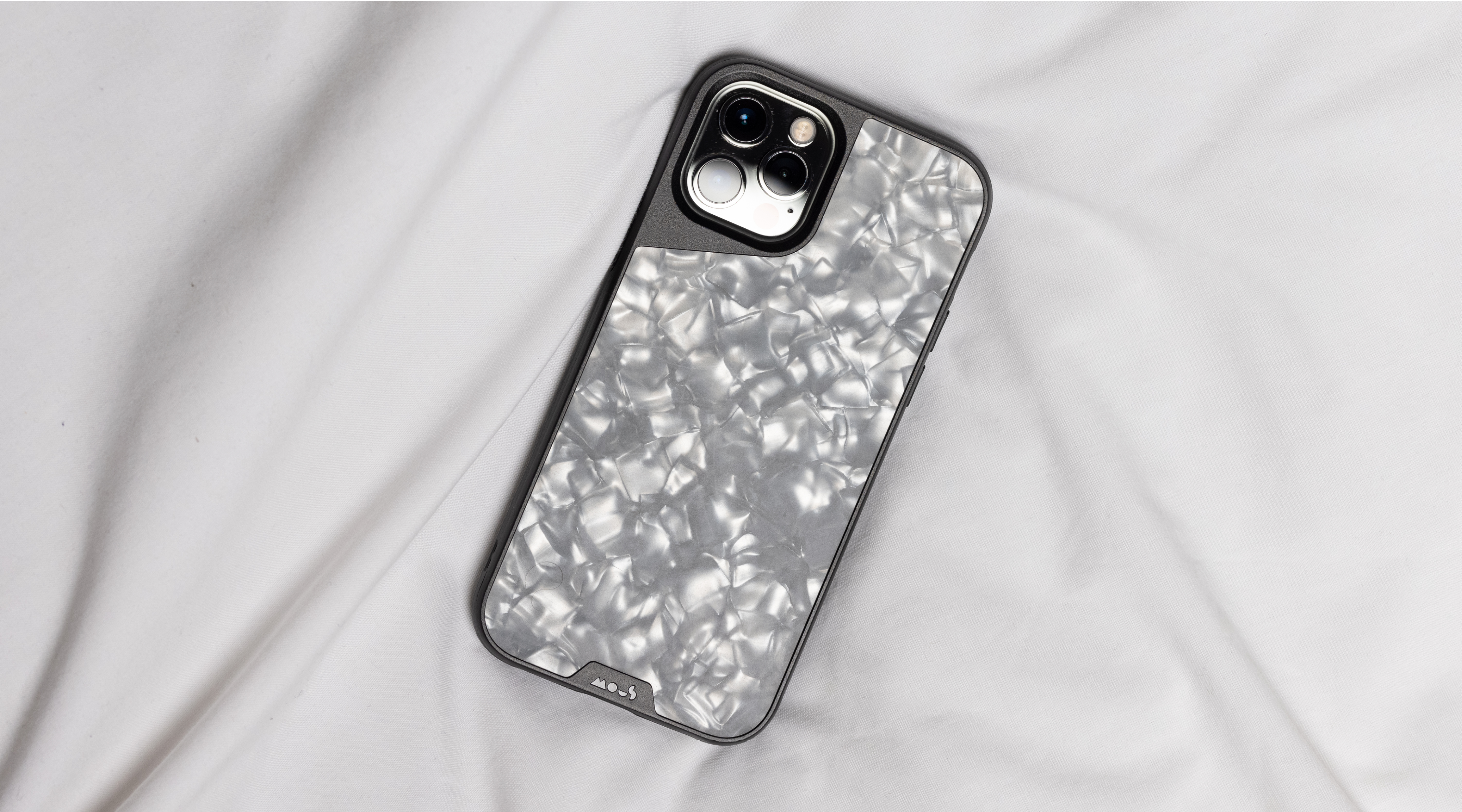 iPhone 12 Pro phone case Limitless 4.0 in silver pearl on a white bed sheet