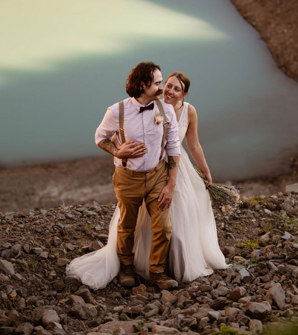 couple hiking with dried floral bouquet for destination wedding 